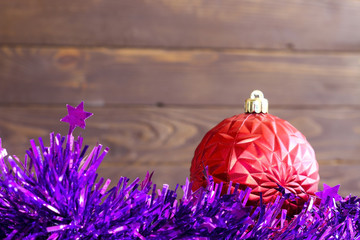 Merry Christmas and happy New Year. Christmas red balls and tinsel on wooden background.