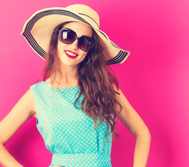 Happy young woman wearing a hat and sunglasses