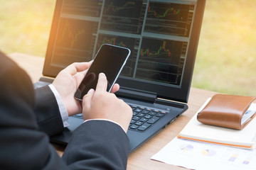Stock Trader Looking At Monitor and  Hands holding smartphone