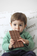 baby eating a tablet of chocolate