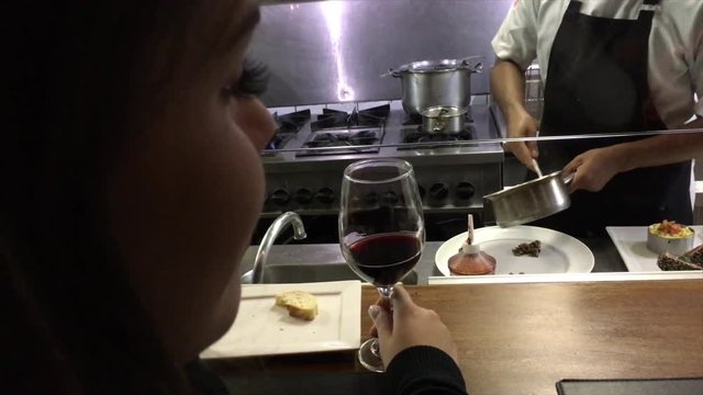 Woman with wine looking of a industrial kitchen in a restaurant