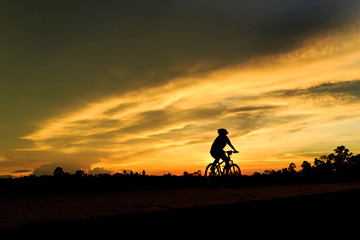Obraz na płótnie Canvas silhouette of girl riding bicycle for health
