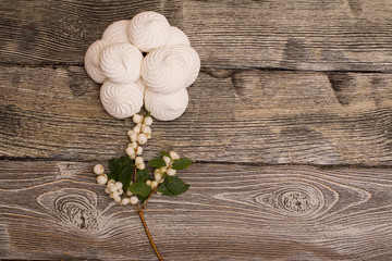 marshmallows with berries on wooden table. rose