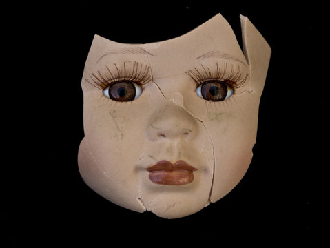 Broken Doll Face and Head on Black Background