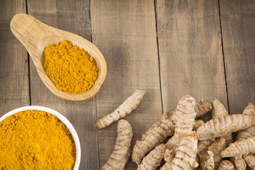 Fresh turmeric roots on wooden table