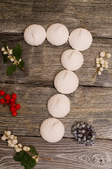 marshmallows with berries on wooden table. number 7
