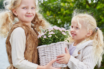 Zwei Mädchen tragen Blumen