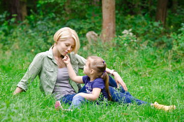 Naklejka na ściany i meble Little daughter gives her mother a flower smell