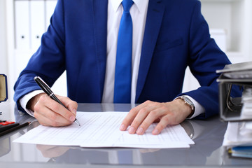 Close up view of bookkeeper or financial inspector hands making report, calculating or checking balance. Internal Revenue Service inspector checking financial document.