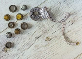 tapeline and old thimbles lie on the light board