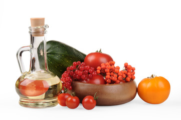 Autumn Still Life. The season of harvest. Zucchini, red and yellow tomatoes, berries of mountain ash and viburnum berries. Olive oil in a jug. . on a white background.