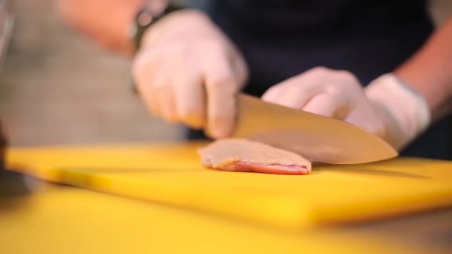 Cook cutting the chicken meat.