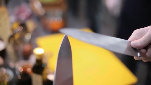 chef sharpens knifes close up.