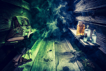Witch hut with potions, scrolls, books and blue, green smoke with copy space for Halloween