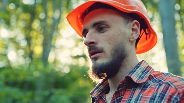 Bearded young logger or lumberjack in a forest