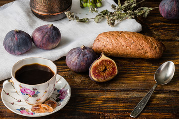 Obraz na płótnie Canvas Cup of coffee with fresh bun and some figs