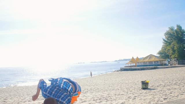 guy athlete does an acrobatic combo tricks on the beach