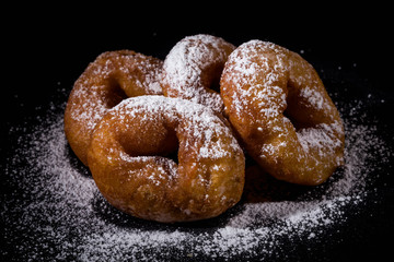 Sprinkling sugar powder on donut