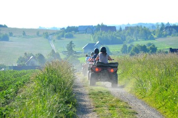 Young people driving a quad bike on a sunny day