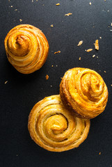 Freshly baked cinnamon rolls on a black background