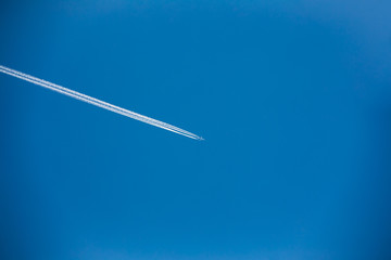 Airplane In Sky With Plane Trails