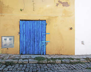 Blue wood door on rustic yellow wall