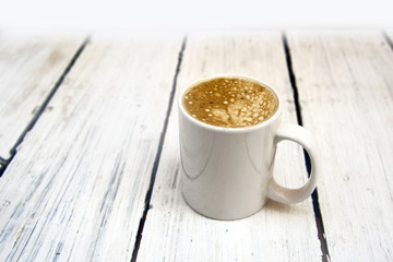 Cup of capuccino on white coarse planks