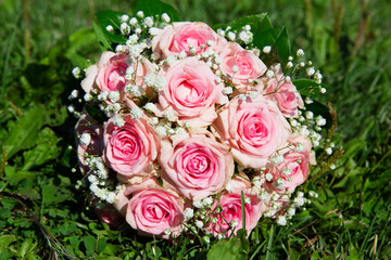 Pink roses bouquet on green grass