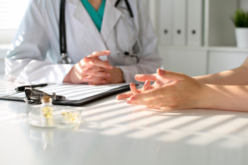 Fototapeta premium Doctor and patient are discussing something, just hands at the table