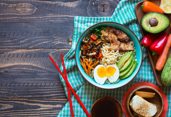 Japanese noodles bowl with chicken, carrots, avocado