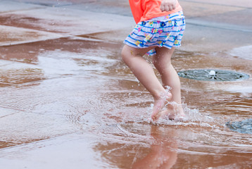 Fototapeta premium Girls feet in water puddle