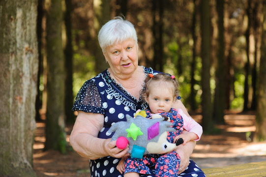 Grandmother and granddaughter walk in the park