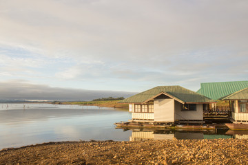 houseboat in lake and green mountain background