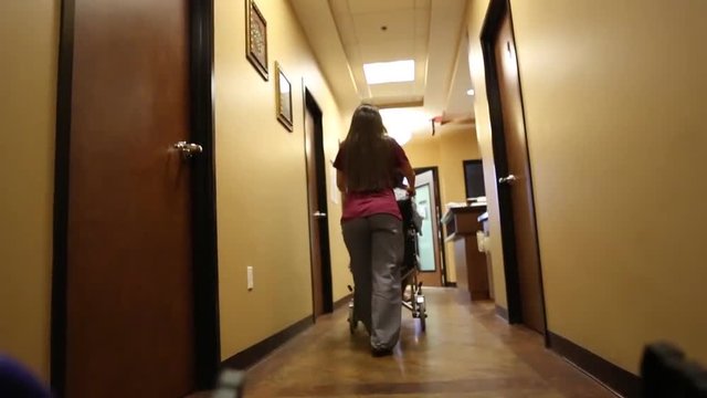 Nurse Pushing Patient in Wheelchair