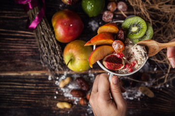 Oatmeal with berries, fruits and nuts in hands