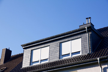 Closeup view on a house with dormer windows, shutter down