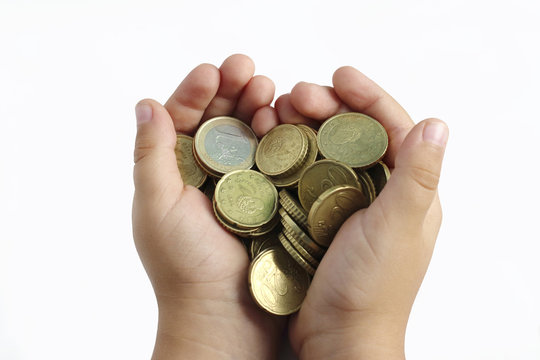 hands of a kid with a lot o golden coins