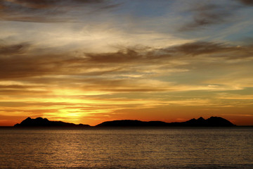 Fototapeta na wymiar cloudy orange sunset in the beach the sun in Cies Island