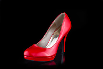 Single red woman high heel shoe isolated on black background