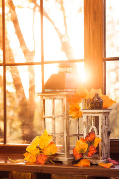 sunlight passes through vintage lanterns, decorated with autumn leaves