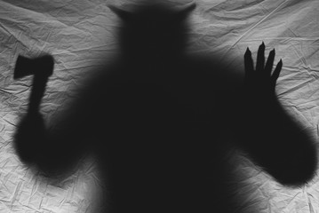 daemon silhouette with horns on a dark background