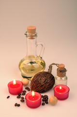 Obraz na płótnie Canvas spa composition. scented candles, coffee beans, aromatic wooden balls and oil in a glass jug with a stopper. partially tinted photo.