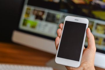 Closeup of smartphone in the hand on office background