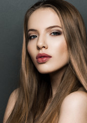 Fototapeta premium Beautiful woman model portrait with long hair on dark background