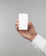 Man's hand holding white card on light background