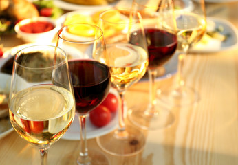 Glasses of different wine on wooden table