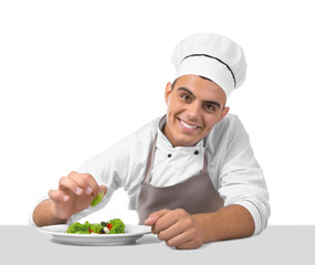 Young handsome chef cook making salad isolated on white