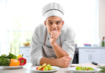 Young chef cook decorating meat dish in kitchen