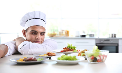 Young handsome chef cook preparing food in kitchen