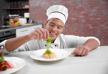 Young handsome chef cook preparing pasta in kitchen